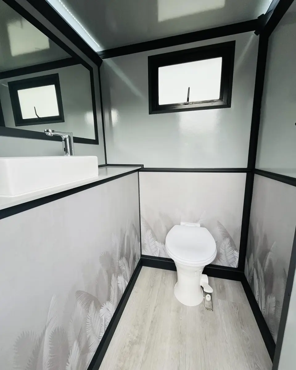 Restroom trailer stall with toilet and window